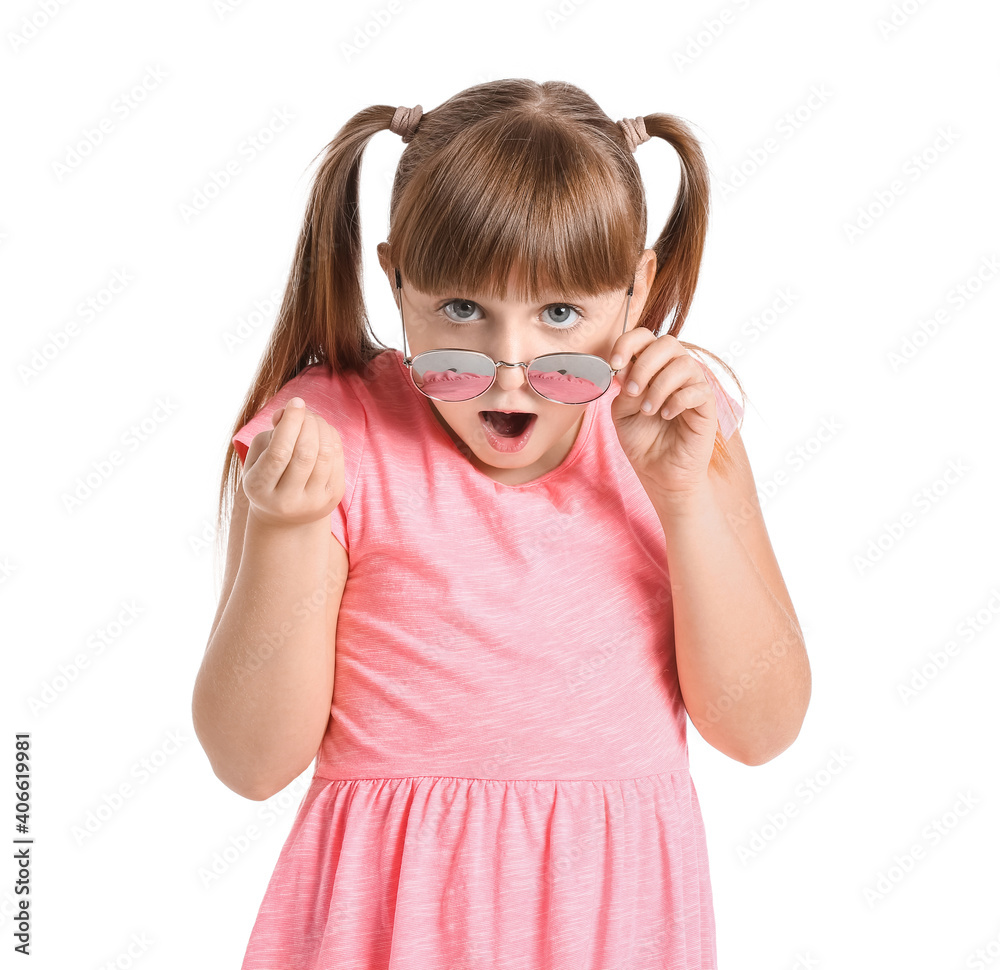 Surprised little girl wearing stylish sunglasses against white background