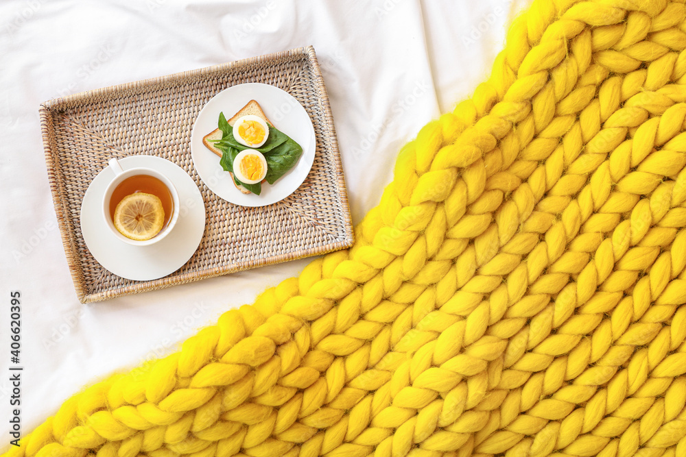 Tray with tasty breakfast on bed