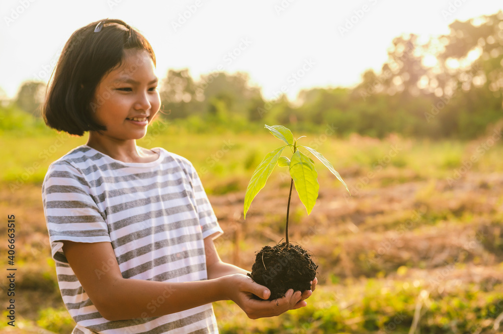 孩子们手扶小树在花园里种植。概念地球日生态