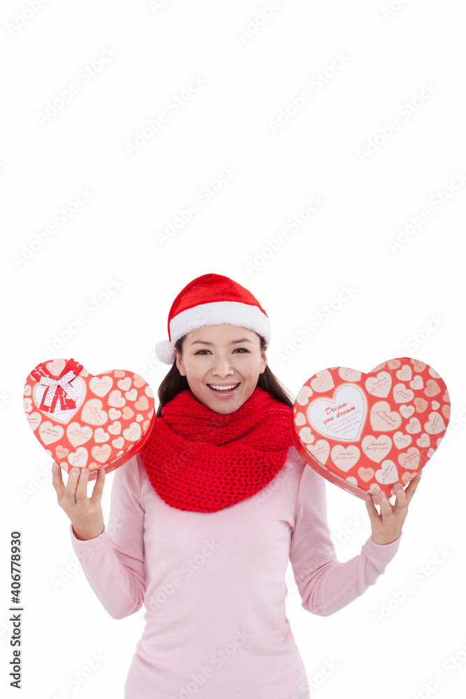 Portrait of young woman wearing Santa hat,holding gifts