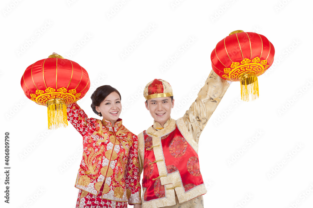 young couple in Tang suits paying New Year call holding red lanterns