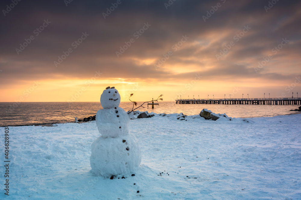 Snowman on the beach of the Baltic Sea in winter at sunrise, Gdynia Orłowo. Poland