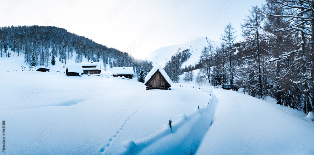 Winter wonderland scenery with traditional mountain cabins in the Alps