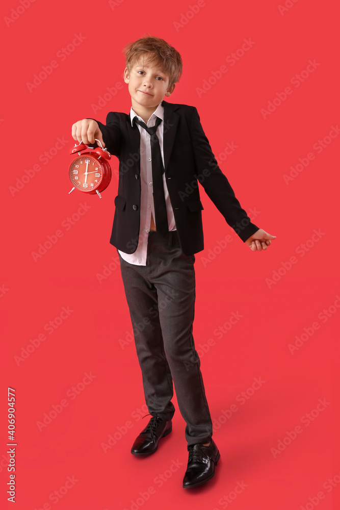 Emotional little businessman with alarm clock on color background