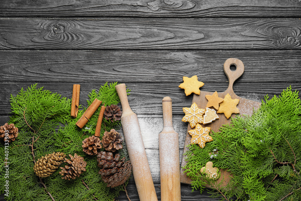 Christmas tree branches, cookies and rolling pins on wooden background