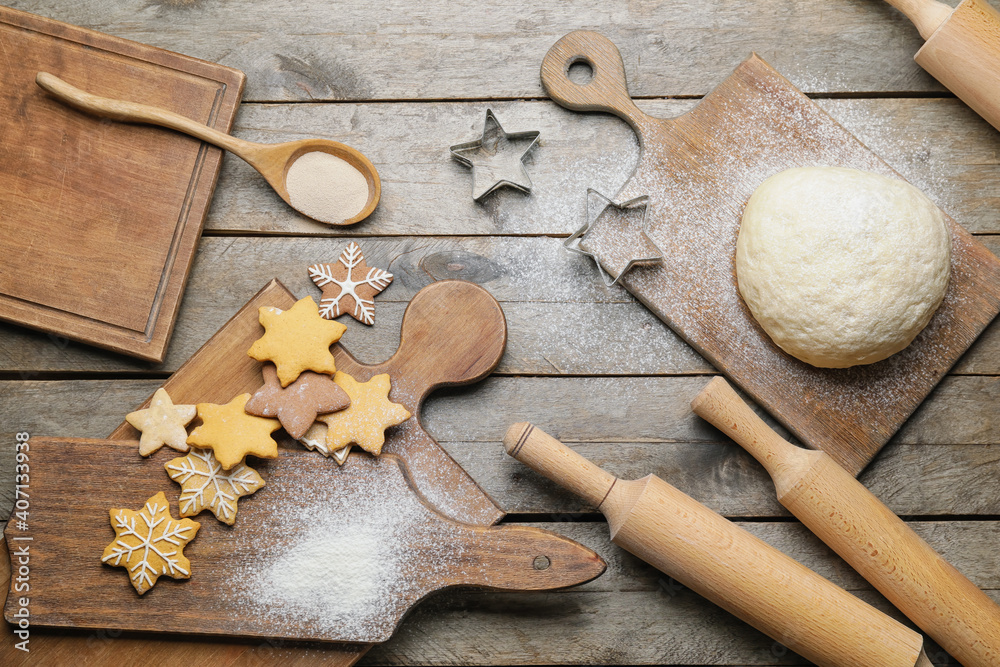 Tasty cookies, dough and rolling pins on wooden background