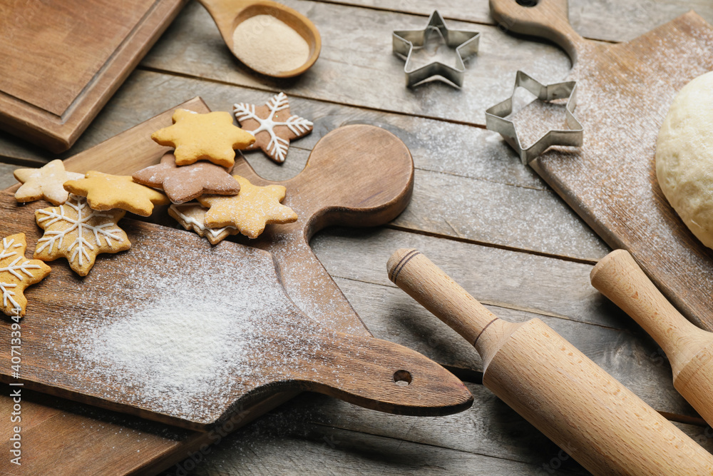 Tasty cookies, dough and rolling pins on wooden background