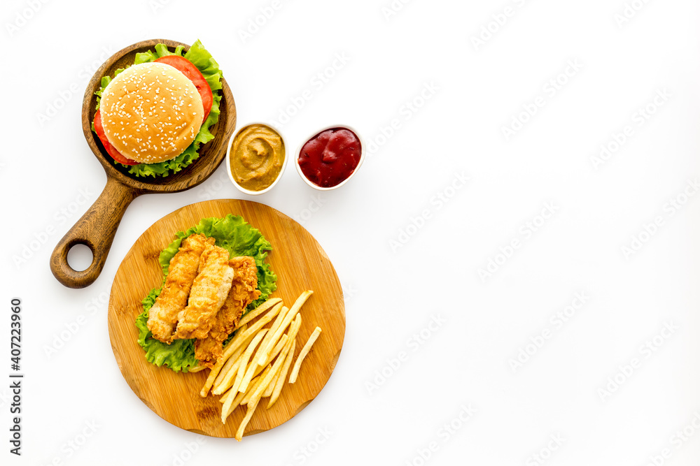 Fast food set. Delicious burger with french fries on wooden cutting board