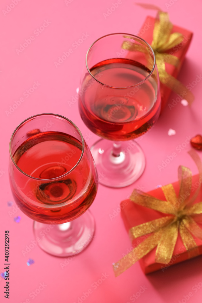 Glasses of wine and gifts for Valentines Day on color background