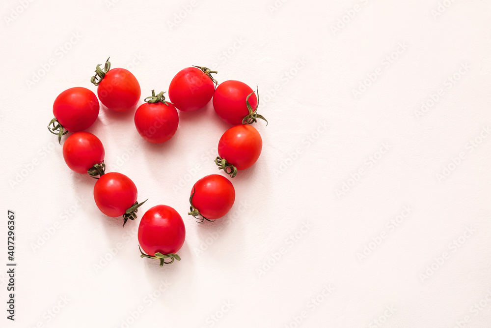 Heart made of fresh tomatoes on white background