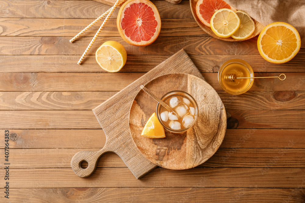 Glass of tasty ice tea on wooden background