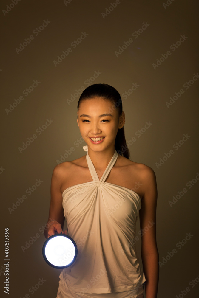 Young woman holding a flashlight