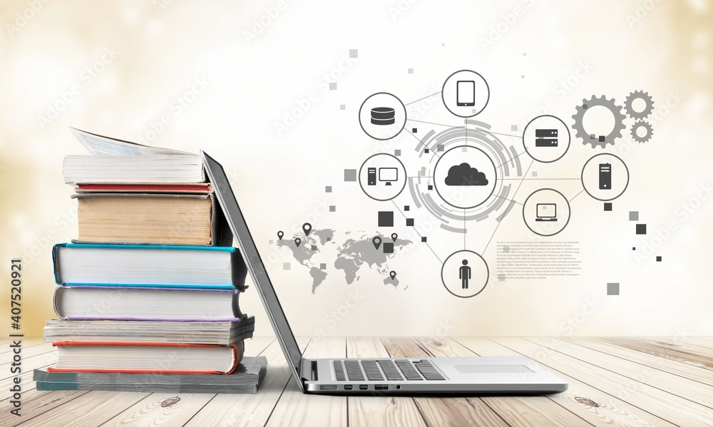 Stack of books with a modern laptop on the table