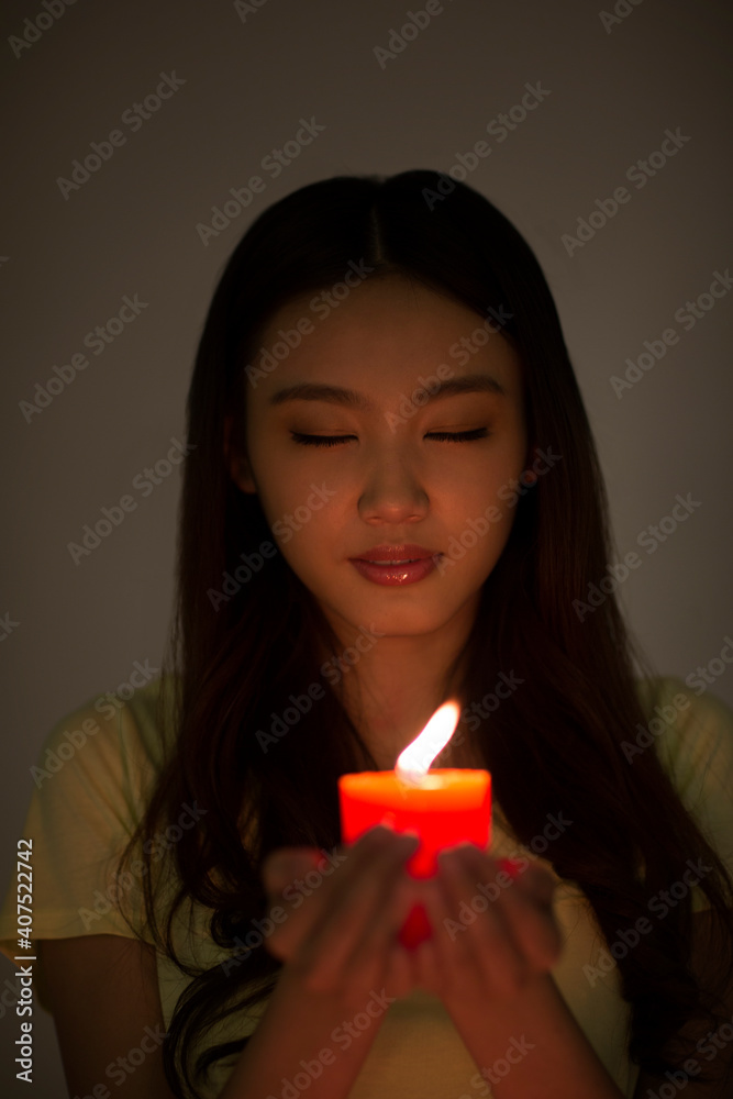 Young woman holding a red candle