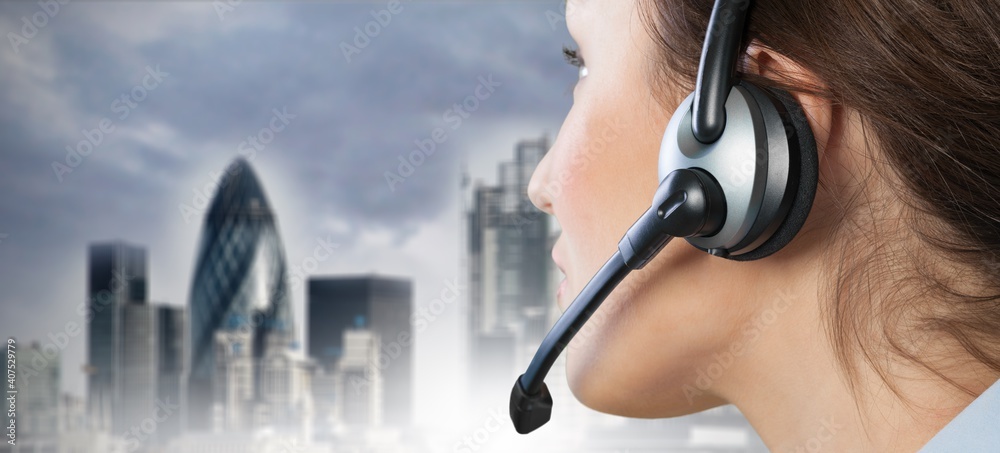 A young woman in headphones with a microphone working in a call center