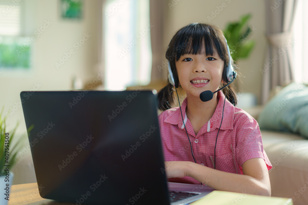 Asian girl student video conference e-learning with teacher and classmates on computer in living roo