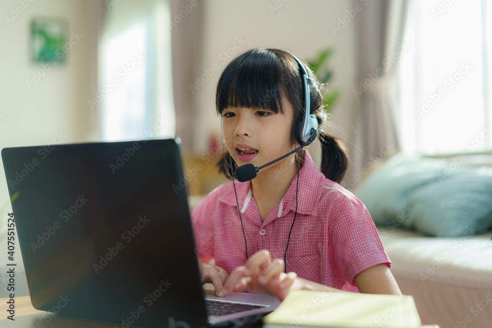 Asian girl student video conference e-learning with teacher and classmates on computer in living roo