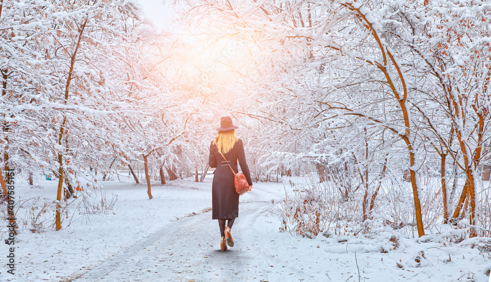 下雪天，孤独的女人在公园里和树散步