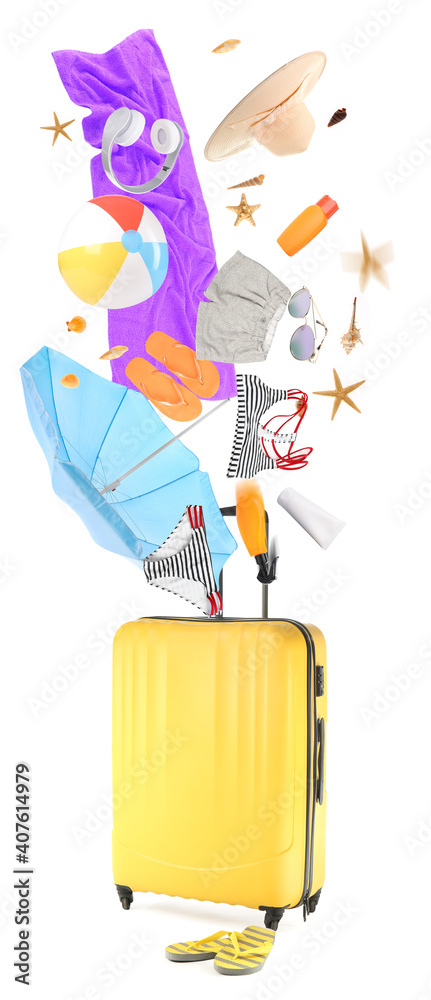 Suitcase with falling beach accessories on white background