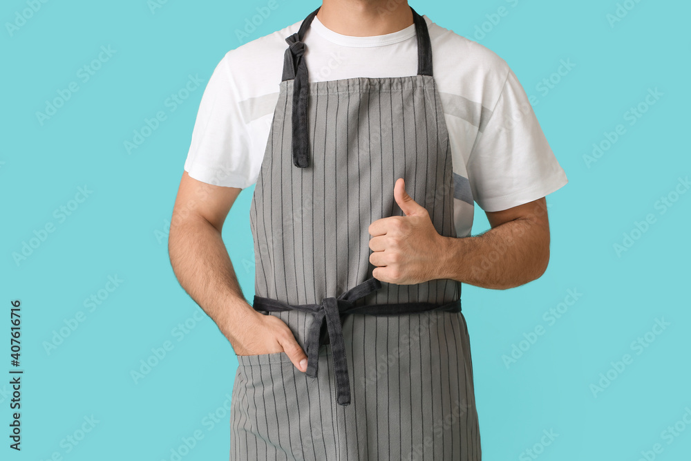 Young man showing thumb-up on color background