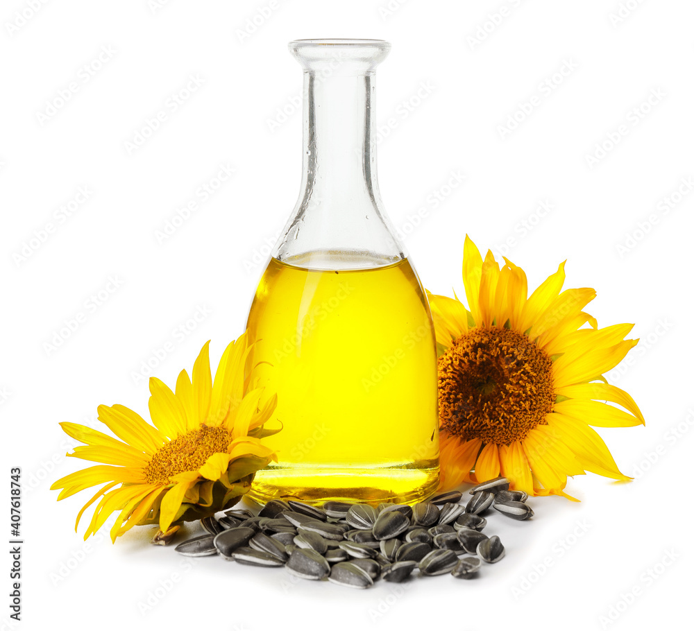 Bottle of oil, seeds and sunflowers on white background