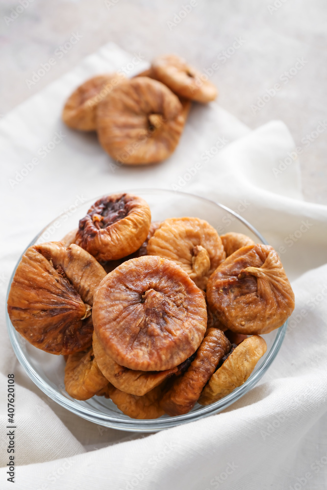 Bowl with tasty dried figs on table