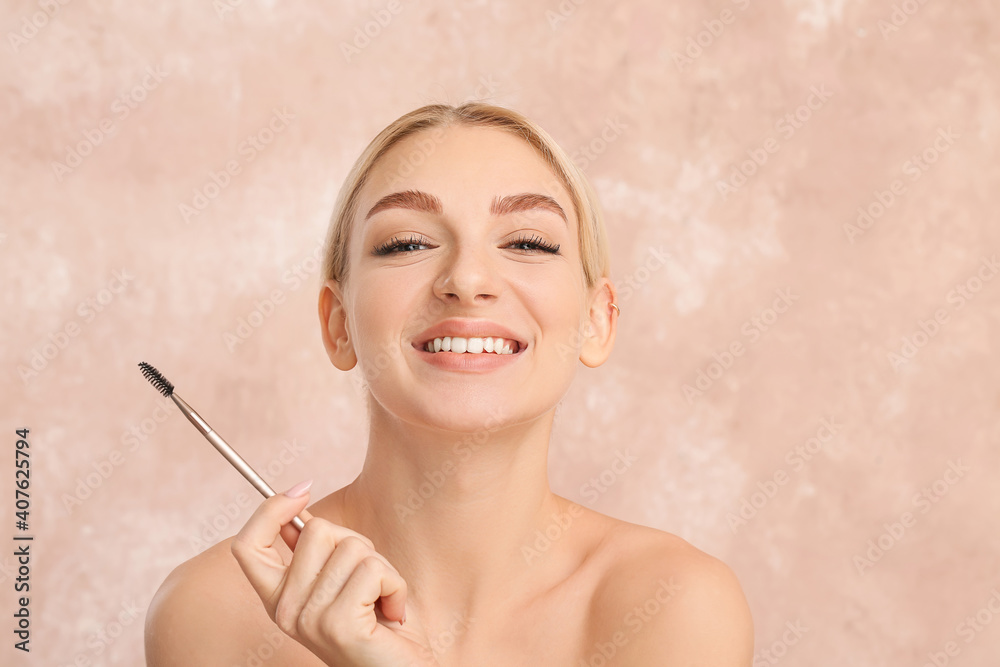 Young woman correcting her eyebrows on color background