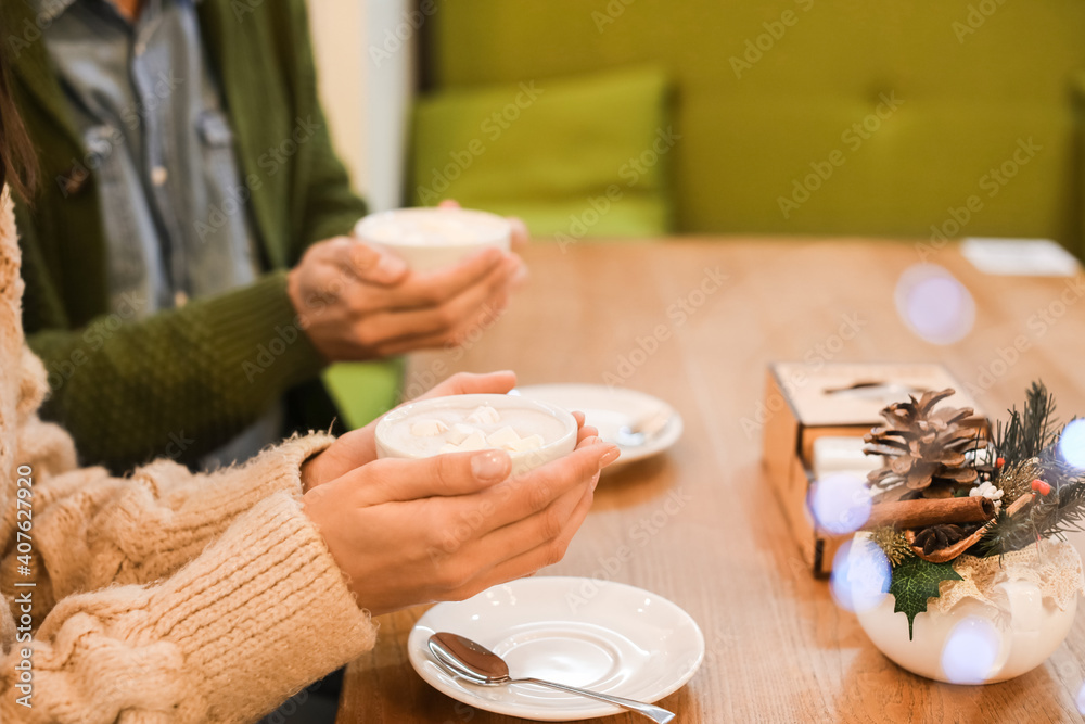 圣诞夜快乐的年轻情侣在咖啡馆喝热巧克力