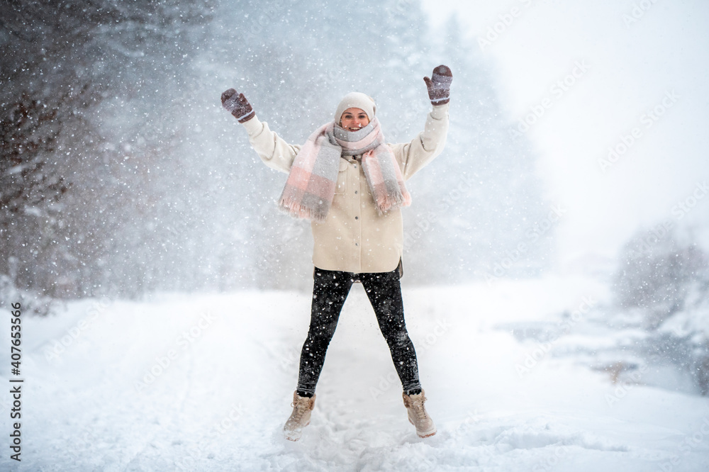 微笑的女人在户外雪地里享受冬天