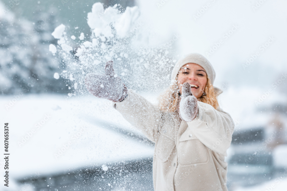 冬天玩耍的女人在公园里扔雪