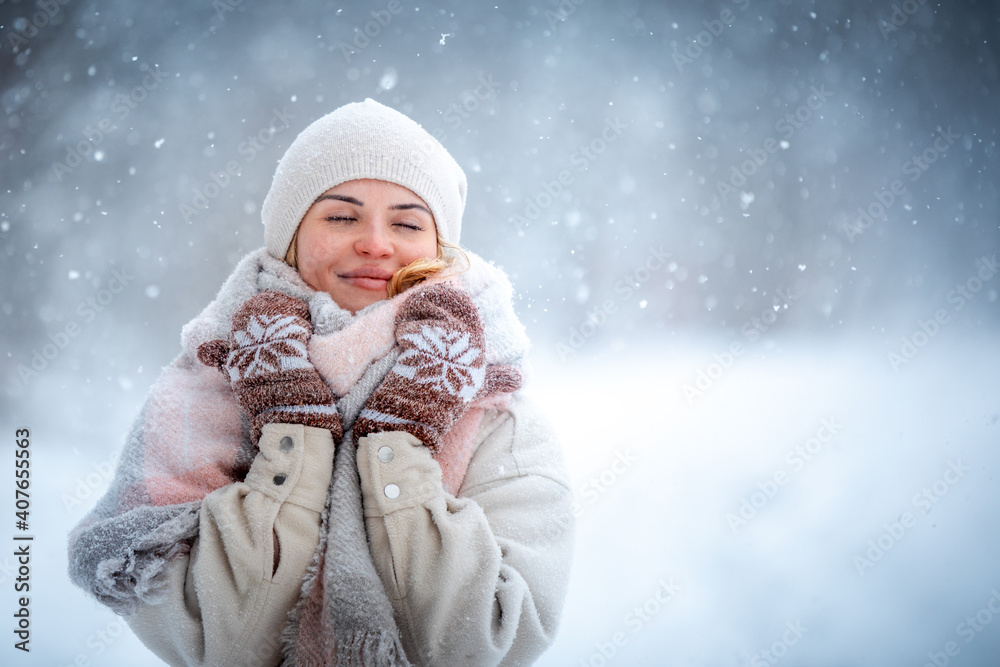 Winter portrait of young woman among snowy park