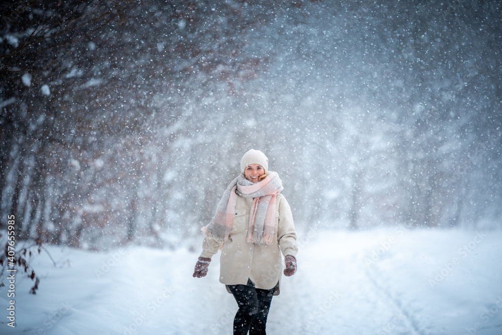 Winter portrait of young woman among snowy park