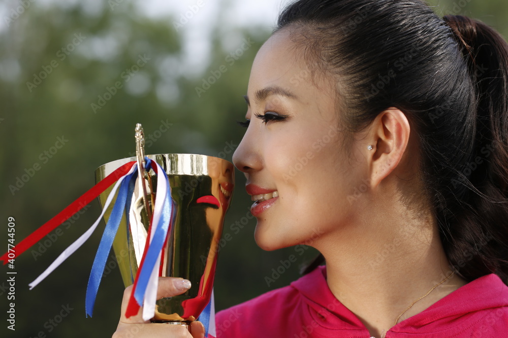 Young woman holding a trophy