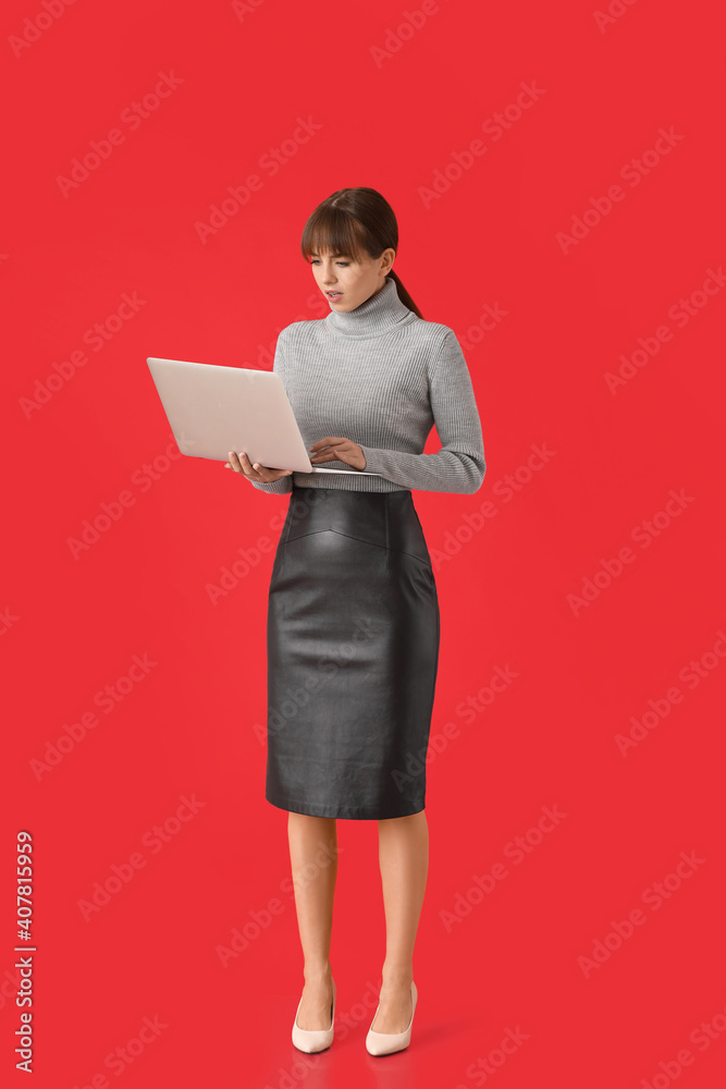 Stressed young woman with laptop on color background. Concept of deadline