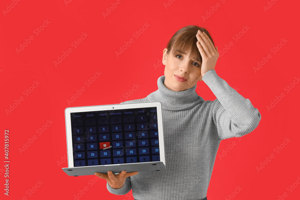 Stressed young woman with laptop on color background. Concept of deadline