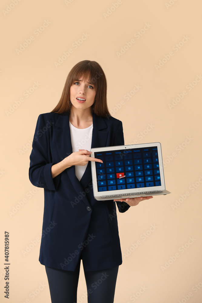 Stressed young woman with laptop on color background. Concept of deadline