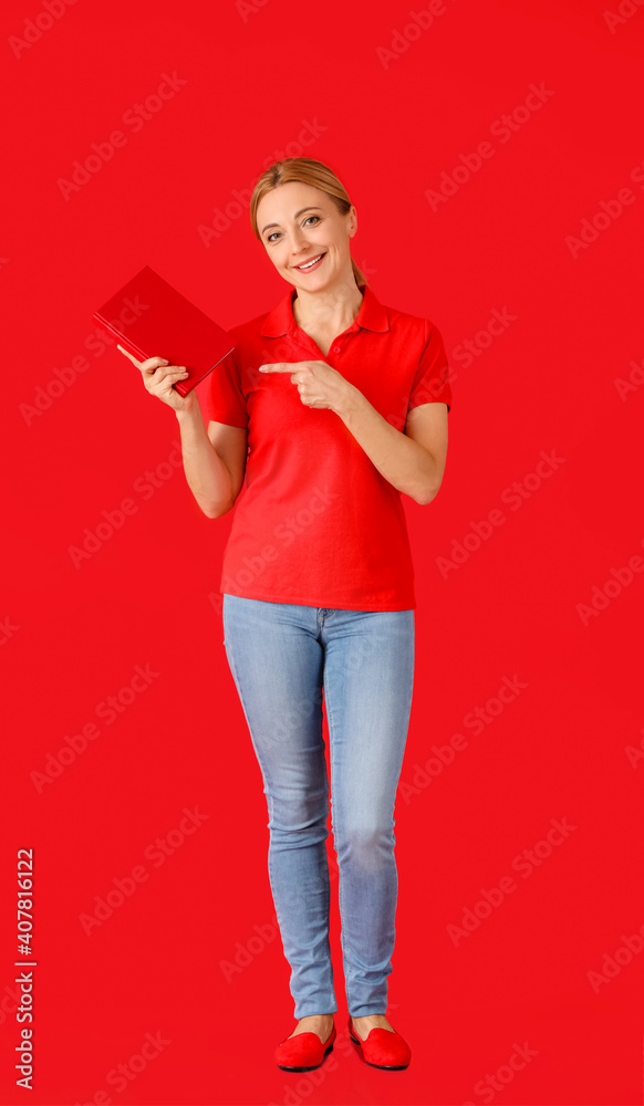 Mature woman with book on color background