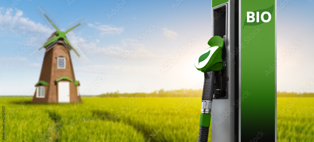 Biofuel filling station on a background of green field with windmill