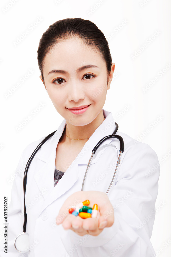 The young female doctor holding a pill