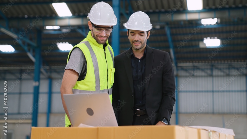 Two factory workers working and discussing manufacturing plan in the factory . Industry and engineer