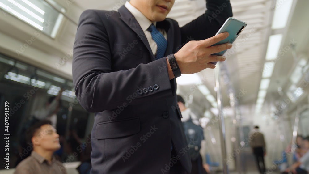 Businessman using mobile phone on public train . Urban city lifestyle commuting concept .