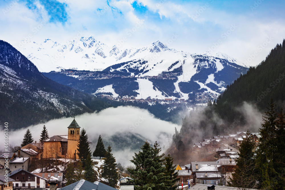 Champagny en Vanoise村庄全景图，古舍维尔度假村上空的老教堂周围云雾缭绕