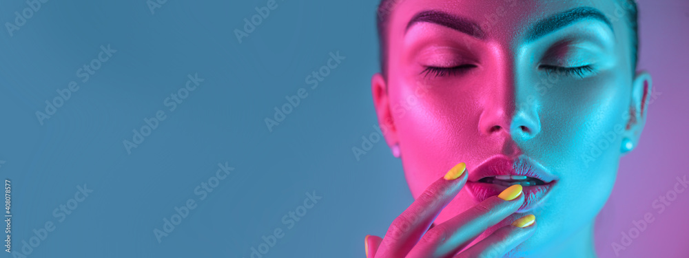 High Fashion model girl in colorful bright UV lights posing in studio, portrait of beautiful woman w