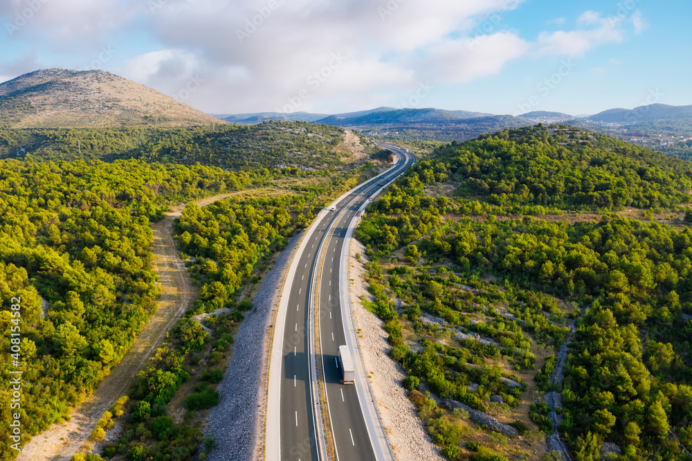 公路鸟瞰图。公路穿越山谷。无人机拍摄。夏季自然景观