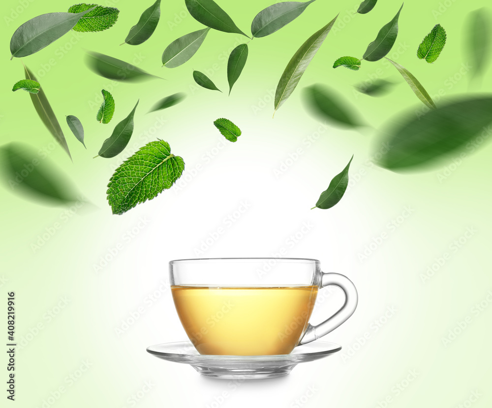 Glass cup and splash of delicious lemon tea with ginger on white background