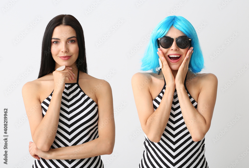 Portrait of young woman with and without wig on light background