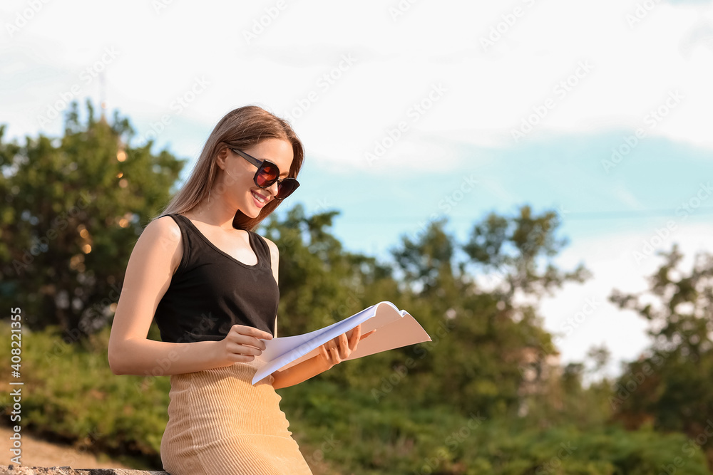 美女在户外阅读空白杂志