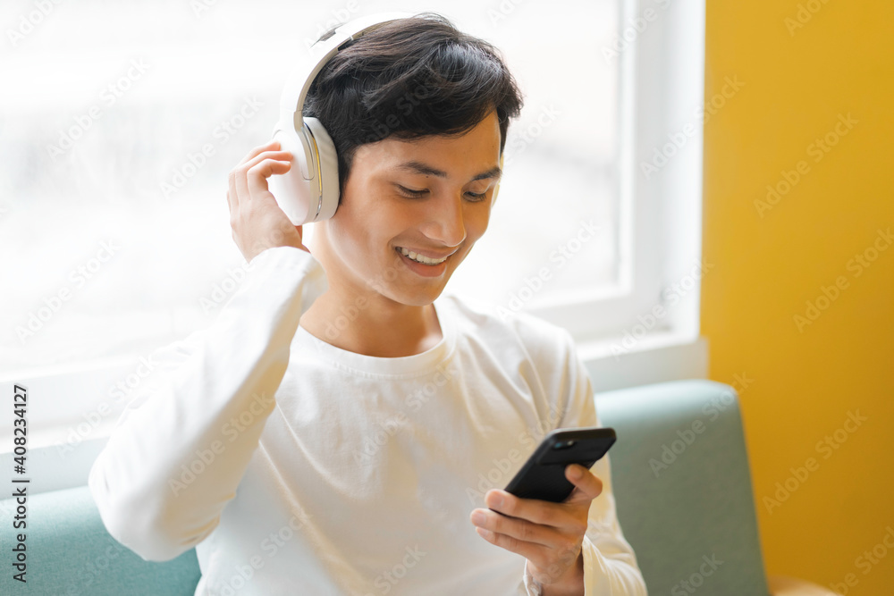 Asian man sitting, enjoying music