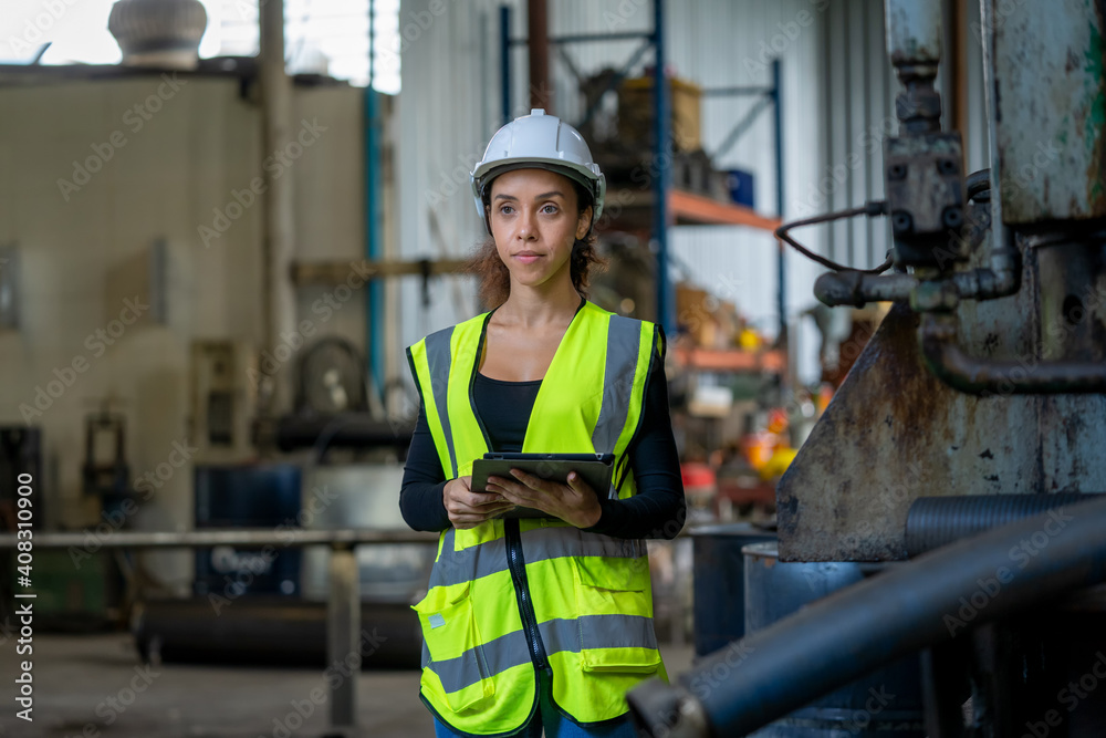 Factory female worker working and checking with clipboard in hands taking necessary notes at plant.