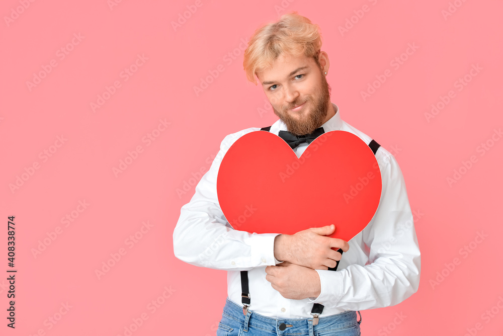 Handsome man with big red heart on color background